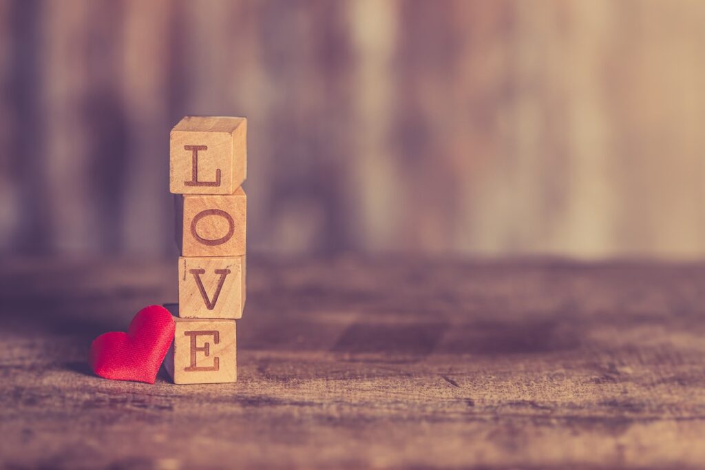 Set of lettered blocks spelling "LOVE" from top to bottom with a heart next to them.