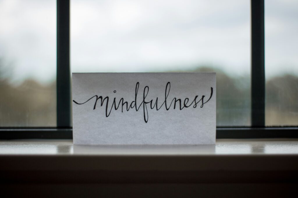 Paper sign that says "mindfulness" on a window sill.