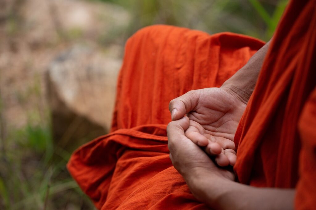 Monk meditating with the cosmic mudra.