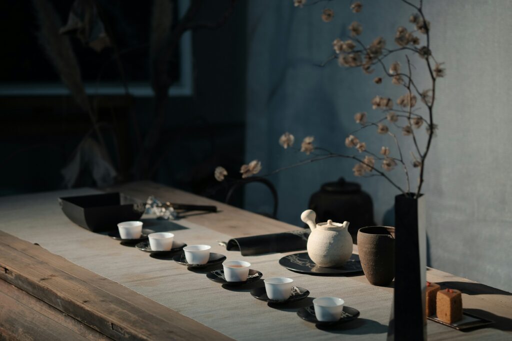 Tea sets arranged in a row on a wooden table.