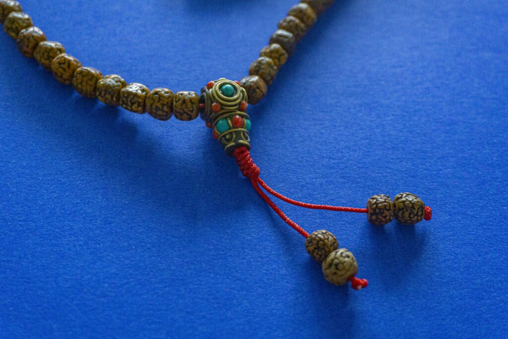 Rudraksha mala beads against a blue background.